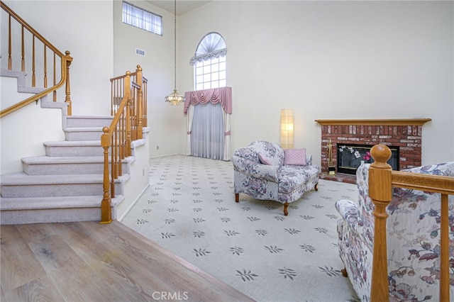 6721 Silver Oak Pl, Riverside, CA 92506 - sitting room featuring a towering ceiling, visible vents, a brick fireplace, carpet flooring, and stairs