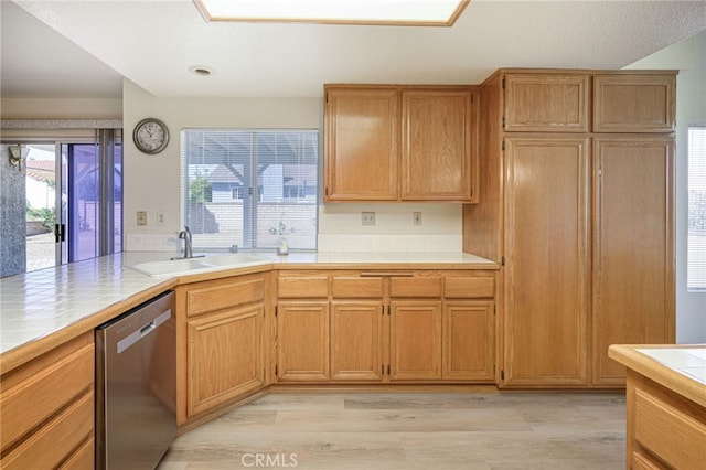 6721 Silver Oak Pl, Riverside, CA 92506 - kitchen with tile counters, light wood-style flooring, stainless steel dishwasher, and a sink