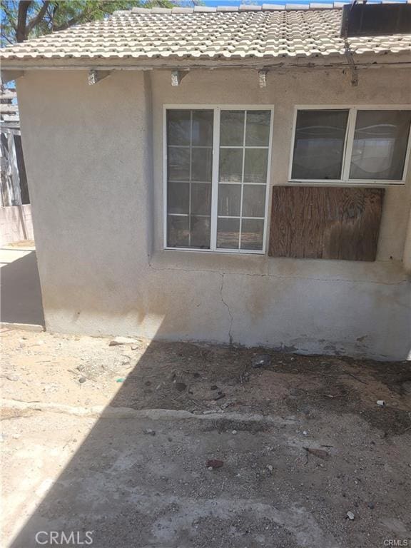21284 Santa Fe Ave, Hinkley, CA 92347 - view of side of home featuring a tile roof and stucco siding