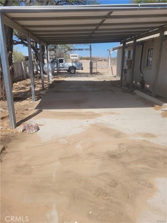 21284 Santa Fe Ave, Hinkley, CA 92347 - view of parking / parking lot featuring concrete driveway, an attached carport, and fence