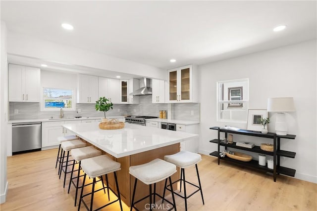 786 Carhart Ave, Fullerton, CA 92833 - kitchen with stainless steel appliances, wall chimney range hood, a kitchen bar, decorative backsplash, and a kitchen island