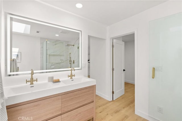 786 Carhart Ave, Fullerton, CA 92833 - bathroom with a marble finish shower, double vanity, a skylight, wood finished floors, and recessed lighting