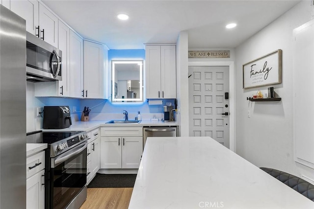 28691 Via Las Flores Unit 328, Murrieta, CA 92563 - kitchen featuring appliances with stainless steel finishes, a sink, light countertops, white cabinets, and recessed lighting