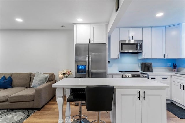 28691 Via Las Flores Unit 328, Murrieta, CA 92563 - kitchen featuring stainless steel appliances, white cabinets, a kitchen island, recessed lighting, and light countertops