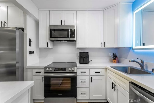 kitchen with white cabinets, stainless steel appliances, and a sink