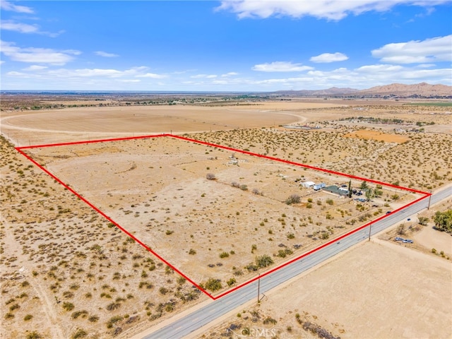 drone / aerial view featuring a mountain view, a desert view, and a rural view