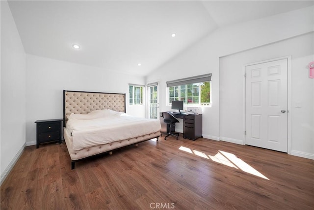 bedroom with vaulted ceiling, baseboards, and wood finished floors