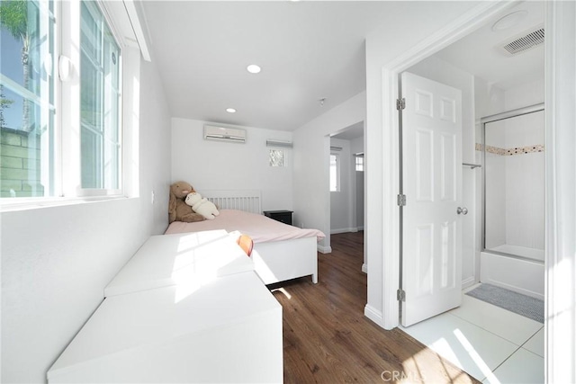 bedroom featuring recessed lighting, wood finished floors, visible vents, a wall unit AC, and baseboards