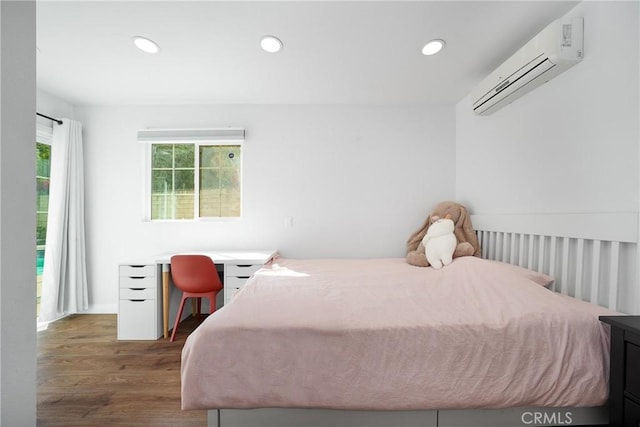 bedroom with wood finished floors, recessed lighting, and a wall unit AC