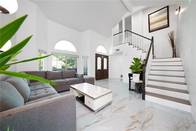 living room with stairway, marble finish floor, visible vents, beam ceiling, and high vaulted ceiling