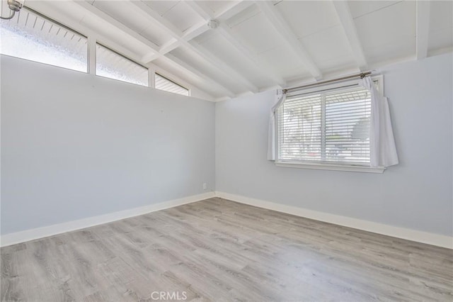 unfurnished room featuring wood finished floors, baseboards, and lofted ceiling with beams
