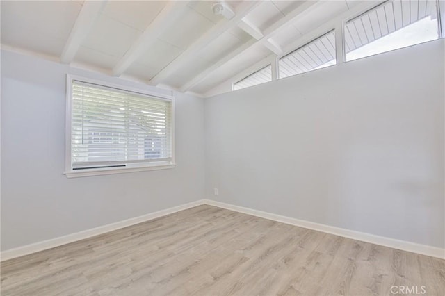 spare room with baseboards, vaulted ceiling with beams, and light wood-style flooring