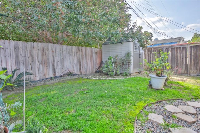 view of yard with a fenced backyard, an outdoor structure, and a shed