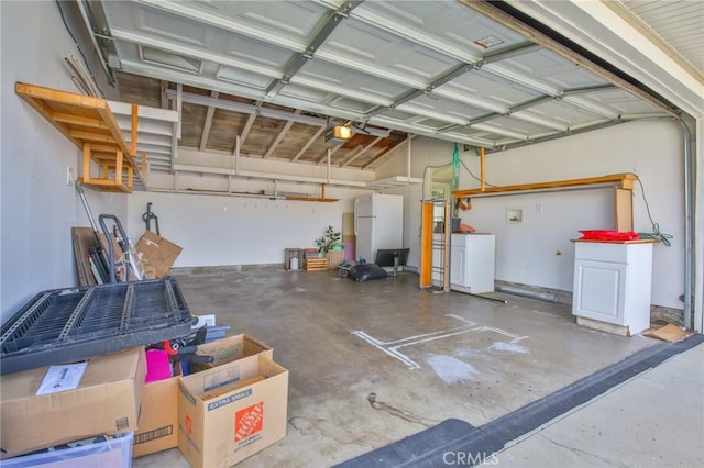 garage featuring freestanding refrigerator and a garage door opener