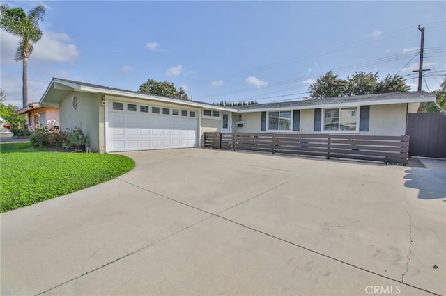 single story home featuring concrete driveway, fence, an attached garage, a front yard, and stucco siding