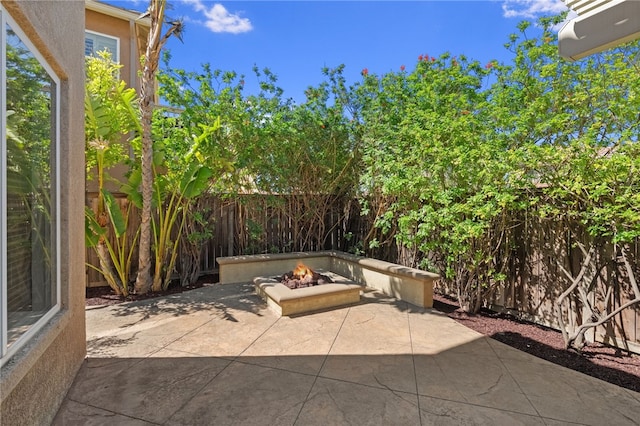 view of patio featuring a fenced backyard and a fire pit