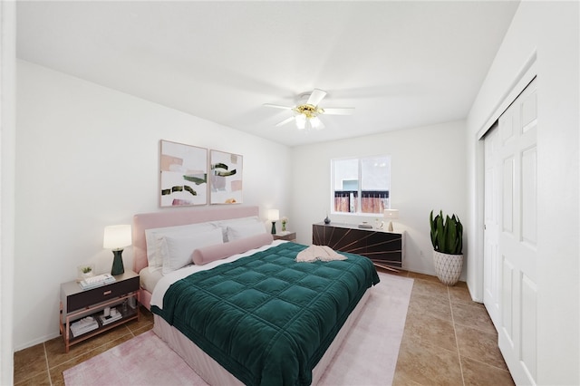 bedroom with light tile patterned floors, ceiling fan, and a closet