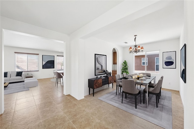 dining room featuring arched walkways and a notable chandelier