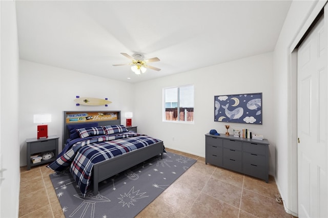 bedroom featuring a closet, a ceiling fan, baseboards, and tile patterned flooring