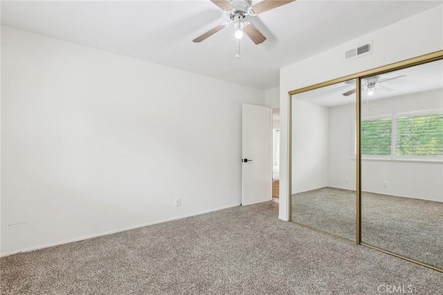 unfurnished bedroom featuring ceiling fan, carpet flooring, visible vents, and a closet