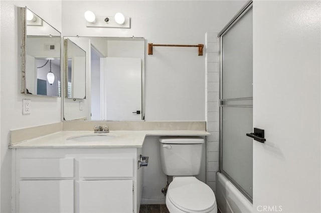 bathroom featuring visible vents, vanity, shower / bath combination with glass door, and toilet