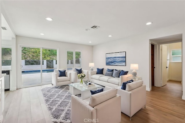 living area featuring baseboards, recessed lighting, visible vents, and light wood-style flooring