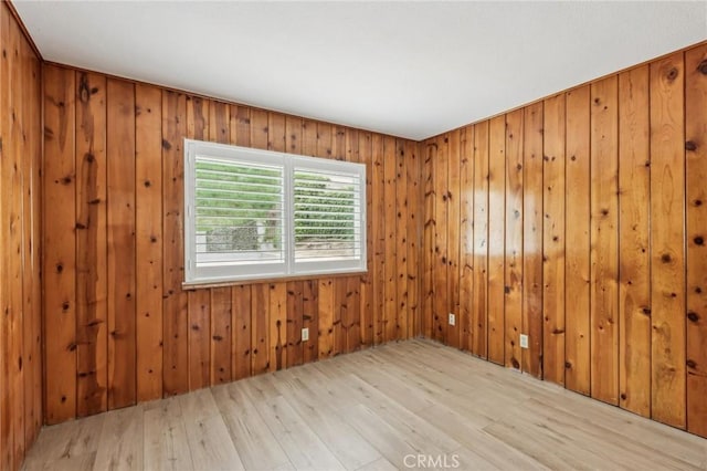 spare room featuring wood finished floors and wooden walls