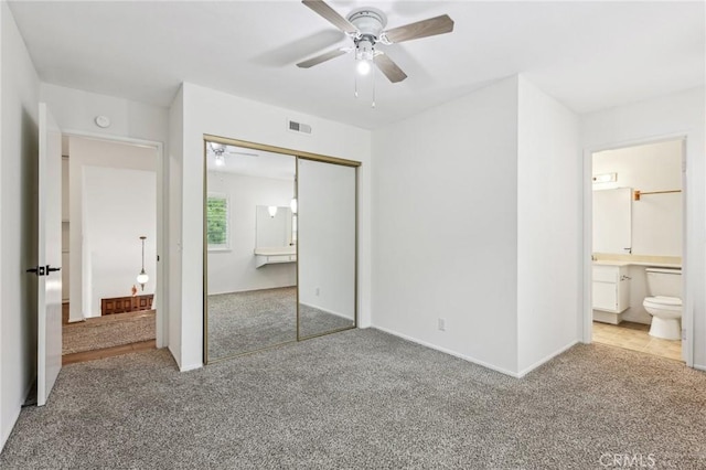 unfurnished bedroom featuring carpet, visible vents, a ceiling fan, connected bathroom, and a closet