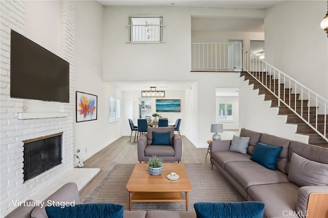 living room featuring stairs, wood finished floors, a high ceiling, and plenty of natural light
