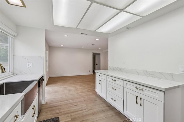 kitchen with light wood-type flooring, visible vents, a wealth of natural light, and white cabinetry
