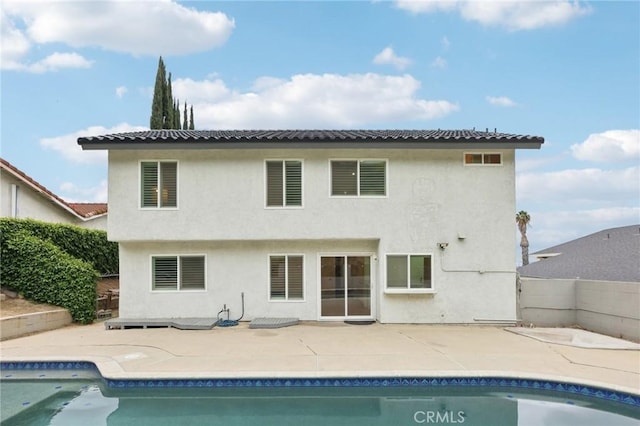 rear view of house featuring a fenced backyard, visible vents, a patio area, an outdoor pool, and stucco siding