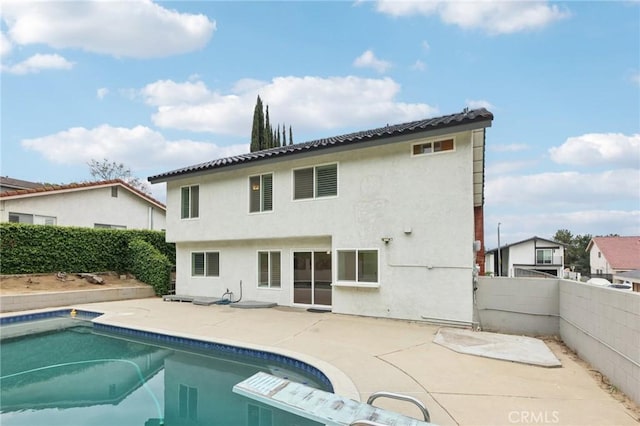 back of house with stucco siding, a fenced in pool, a patio, and a fenced backyard