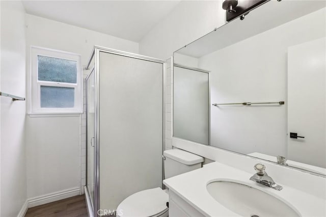 full bath with wood finished floors, vanity, a shower stall, and toilet