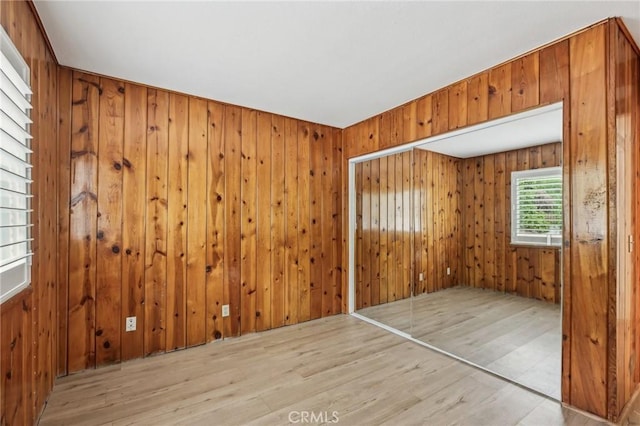 empty room with wooden walls and wood finished floors