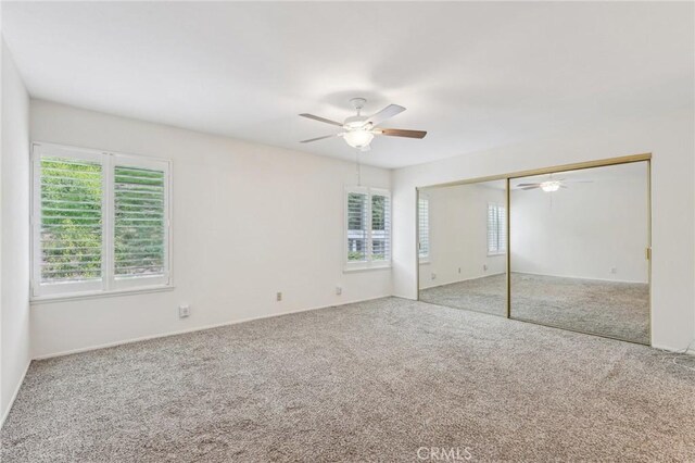 unfurnished bedroom featuring baseboards, carpet, a closet, and ceiling fan