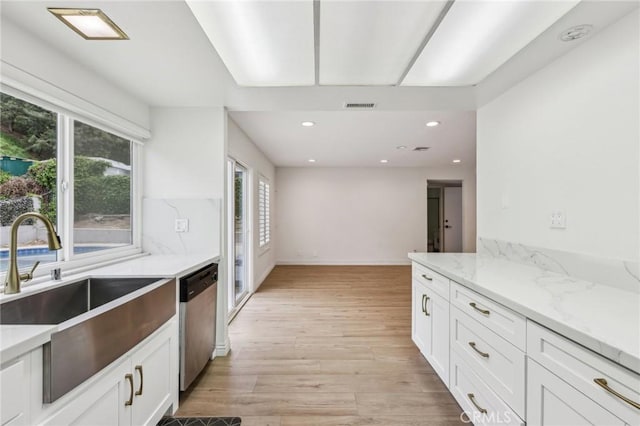 kitchen featuring white cabinets, dishwasher, visible vents, and a sink