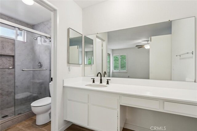 bathroom featuring a healthy amount of sunlight, a shower stall, and toilet