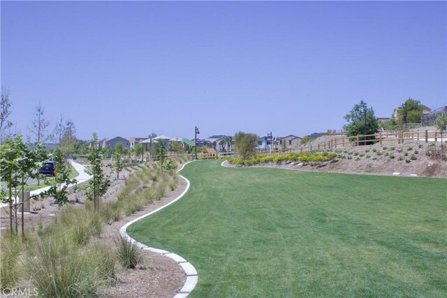 view of home's community featuring a residential view, a lawn, and fence