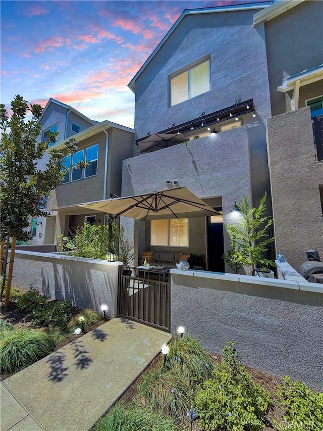 contemporary house featuring a gate, a fenced front yard, and stucco siding
