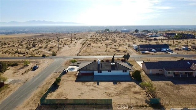 drone / aerial view featuring a mountain view and view of desert