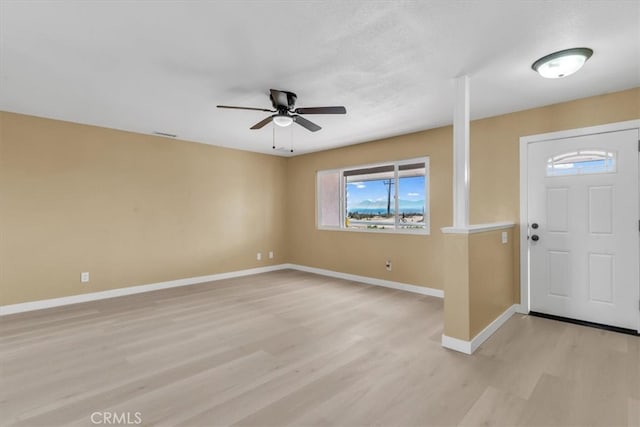 foyer entrance with ceiling fan, baseboards, visible vents, and light wood finished floors