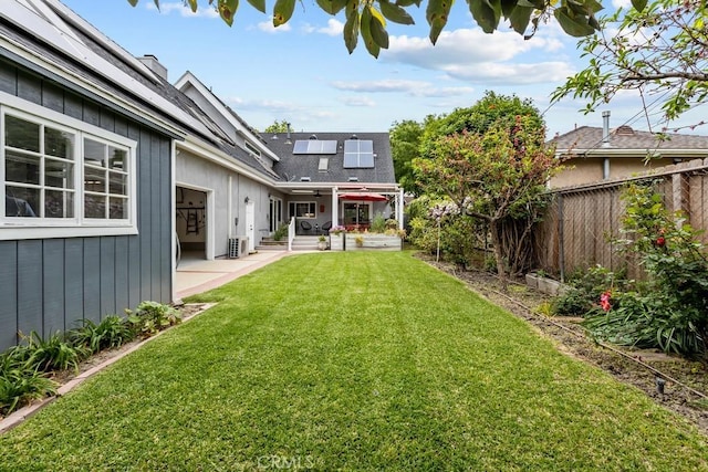 view of yard with a patio area, a fenced backyard, a ceiling fan, and central AC