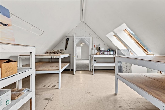 interior space with vaulted ceiling with skylight and tile patterned floors