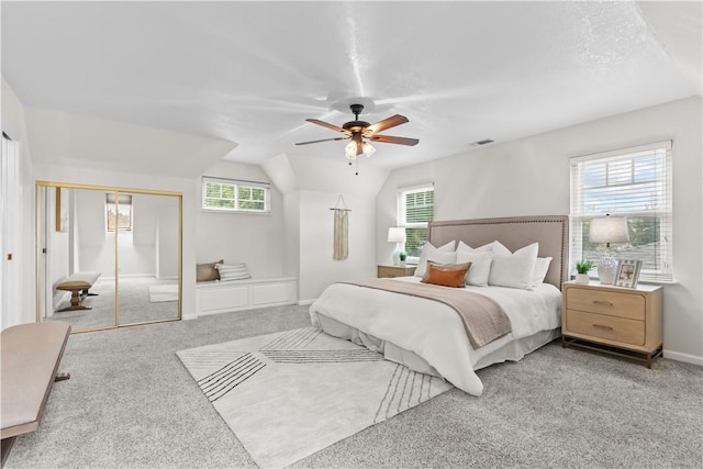 carpeted bedroom with vaulted ceiling, visible vents, and a ceiling fan