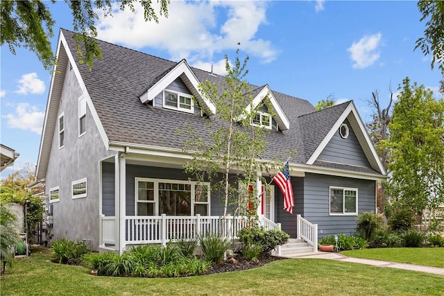 view of front facade featuring roof with shingles, a porch, and a front lawn