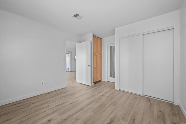 10774 Dabney Dr Unit 17, San Diego, CA 92126 - unfurnished bedroom with light wood-style flooring, baseboards, and a closet