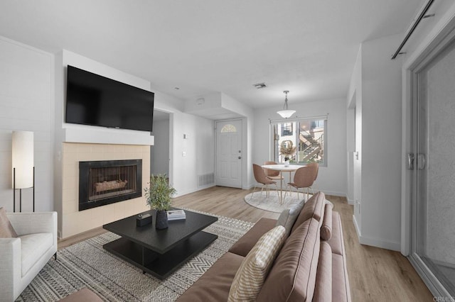 10774 Dabney Dr Unit 17, San Diego, CA 92126 - living area featuring light wood-style floors, a fireplace, and baseboards