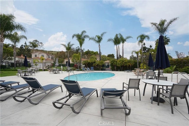 community pool with fence and a patio area