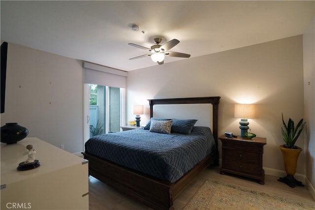 bedroom featuring ceiling fan, baseboards, and light wood-style flooring