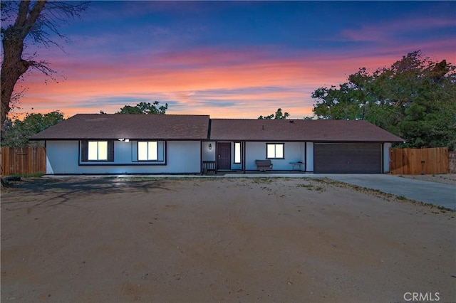 view of front of home with fence, an attached garage, and driveway